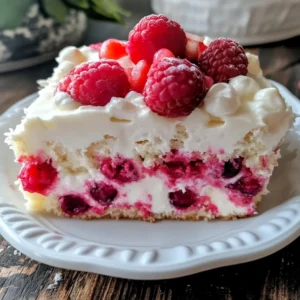 Slice of white chocolate raspberry poke cake with dripping ganache and fresh raspberries on top.