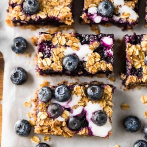 Healthy blueberry oatmeal bars with crumb topping on wooden cutting board