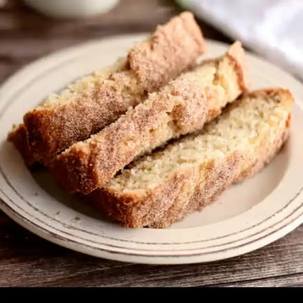 Snickerdoodle_Zucchini_1_result A perfect, thick slice of Snickerdoodle Zucchini Bread on a white plate, showing the moist, tender crumb and the ribbon of cinnamon in the middle.
