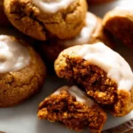 A close-up of a single pumpkin pie cookie with a bite taken out, showing the soft and chewy texture inside.