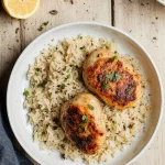 Crock-Pot lemon chicken and rice in a white bowl with juicy chicken thighs and fluffy jasmine rice