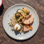 Close-up of sticky mango teriyaki salmon with fresh mint and sesame seeds