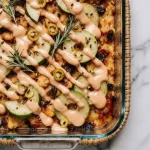 Golden-brown rosemary apple cider chicken thighs in a cast-iron skillet with caramelized apples and a glossy cider sauce.